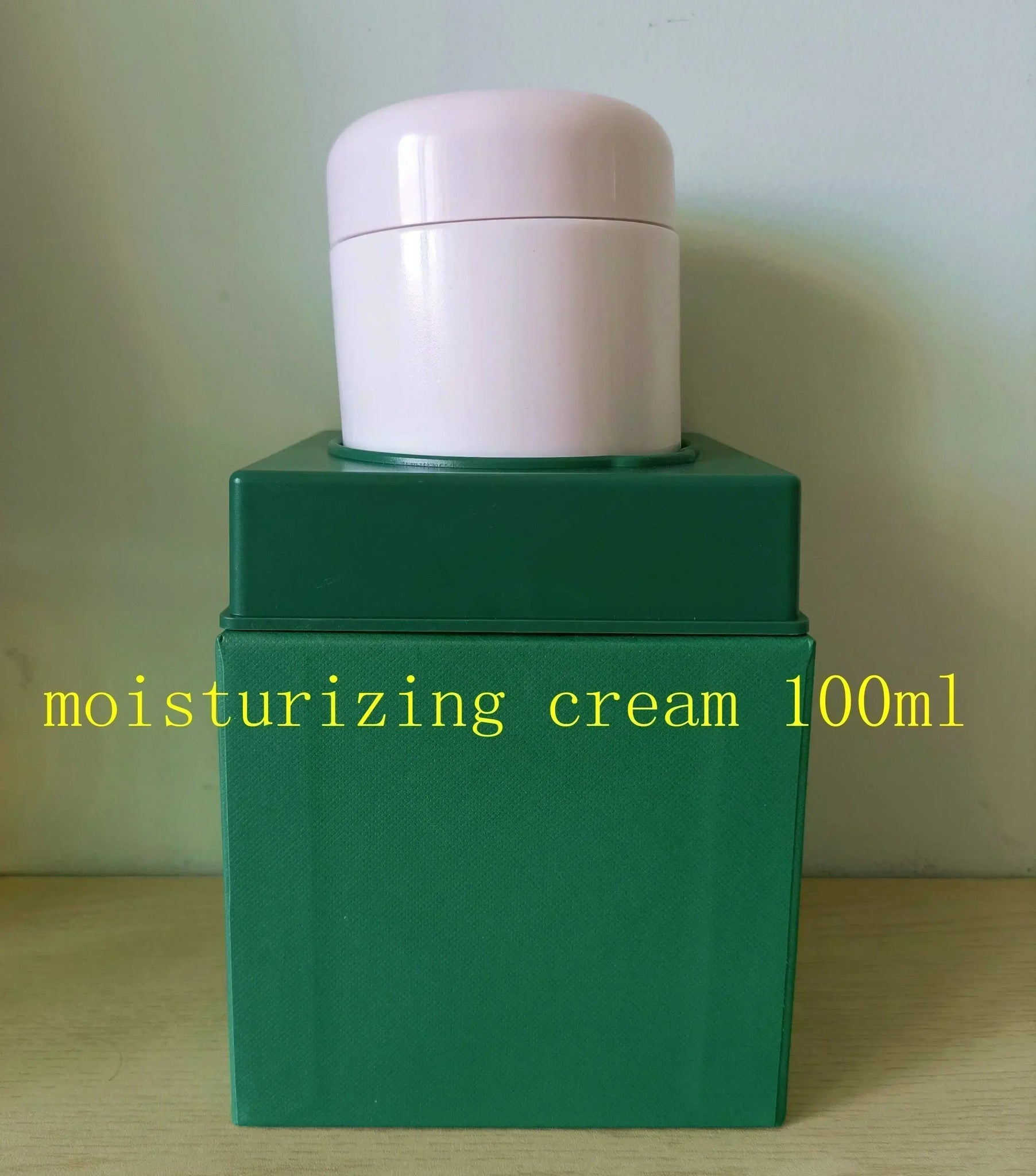 Moisturizing cream 100ml in green packaging with a pink lid, suitable for hydration and skincare.