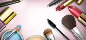 Colorful makeup products including lipsticks, brushes, and eyeshadow arranged on a pink background.
