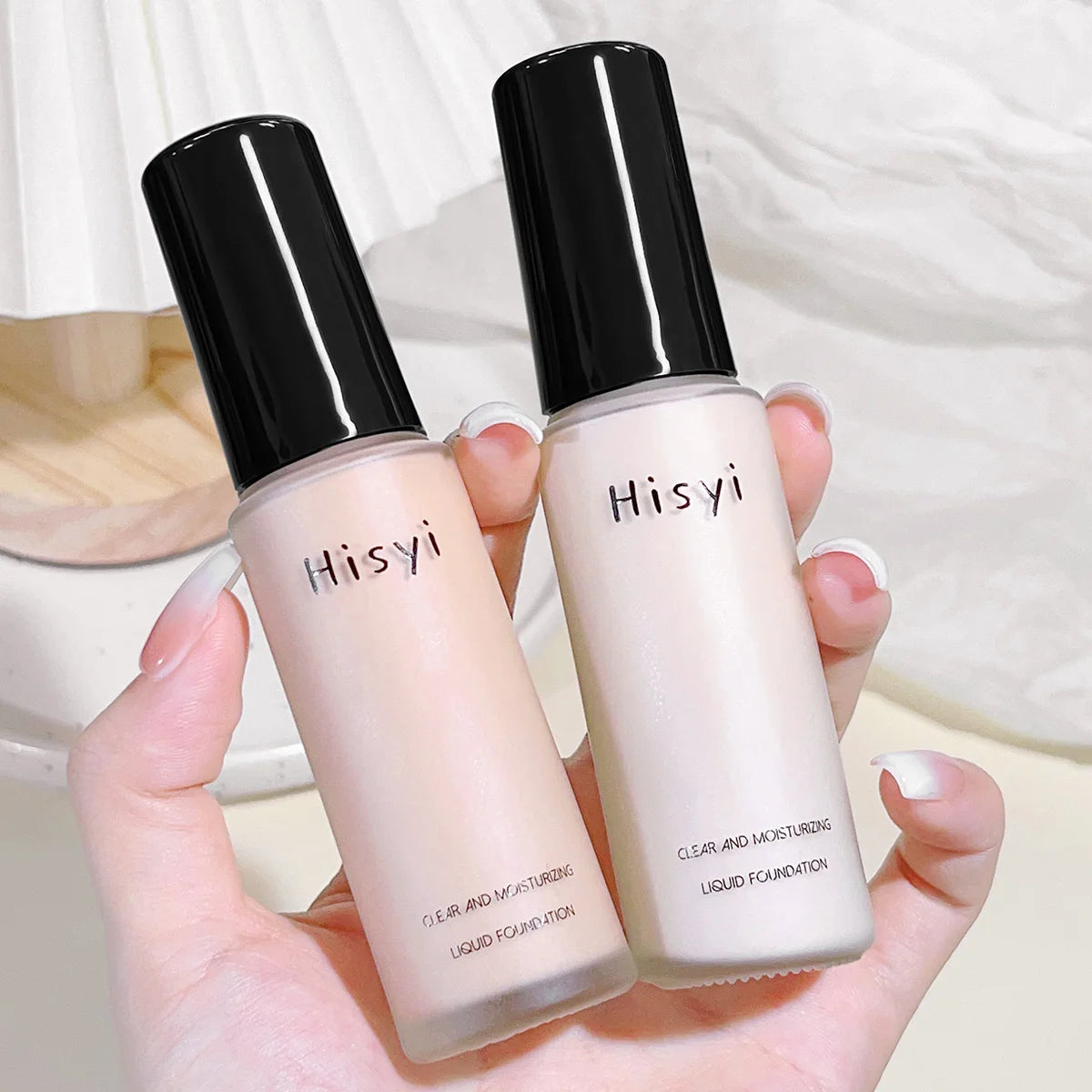 HisyI liquid foundation bottles showcasing a clear and moisturizing formula, perfect for all skin tones.
