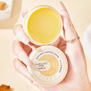 Soothing chapping cream in a hand, 20g container, moisturizing for dry skin on hands and feet.
